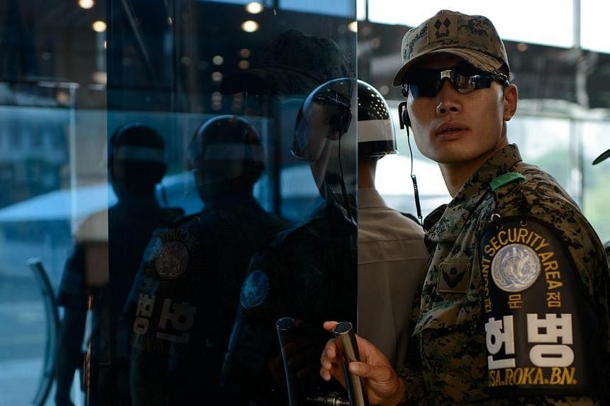 A South Korean soldier at the north-facing entrance to Freedom House, beside the military demarcation line seperating North and South Korea within the Joint Security Area (JSA) at Panmunjom on July 27, 2014. North and South Korea held their first hig