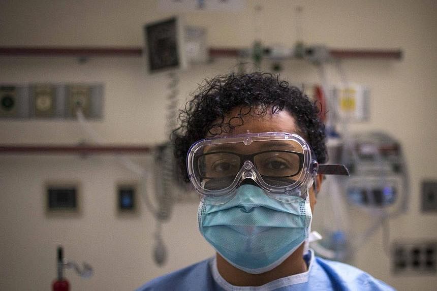 A health-care worker displays protective gear, which hospital staff would wear to protect them from Ebola, at the Bellevue Hospital in Manhattan. Since the first US Ebola diagnosis in Dallas last month, demand for hazardous materials suits and face m