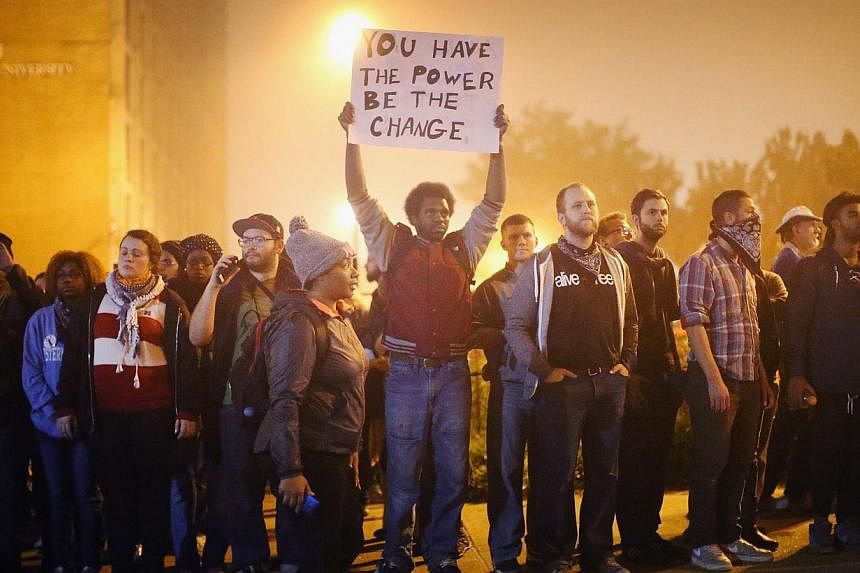 Demonstrators march through the street on Oct 13, 2014, in St Louis, Missouri. -- PHOTO: AFP
