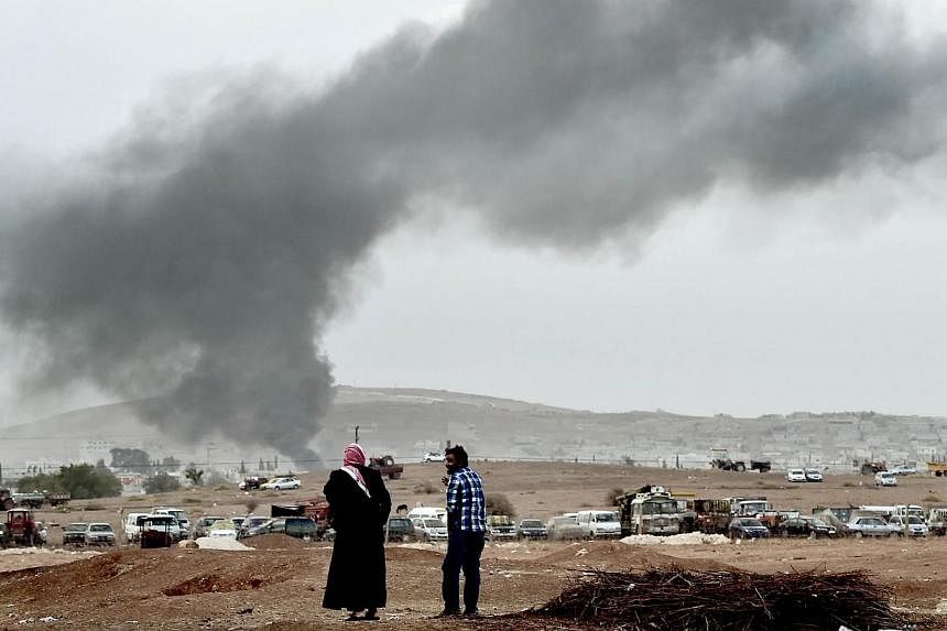 Smoke rises from the the Syrian town of Ain al-Arab, known as Kobane by the Kurds, after a strike from the US-led coalition on Oct 14, 2014. -- PHOTO: AFP