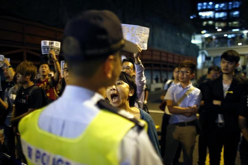 A pro-democracy protester yells at a police officer as she block a street at the entrance of police headquarters at Wan Chai district in Hong Kong on Oct 15, 2014.&nbsp;British Prime Minister David Cameron said on Wednesday that Britain should stand 