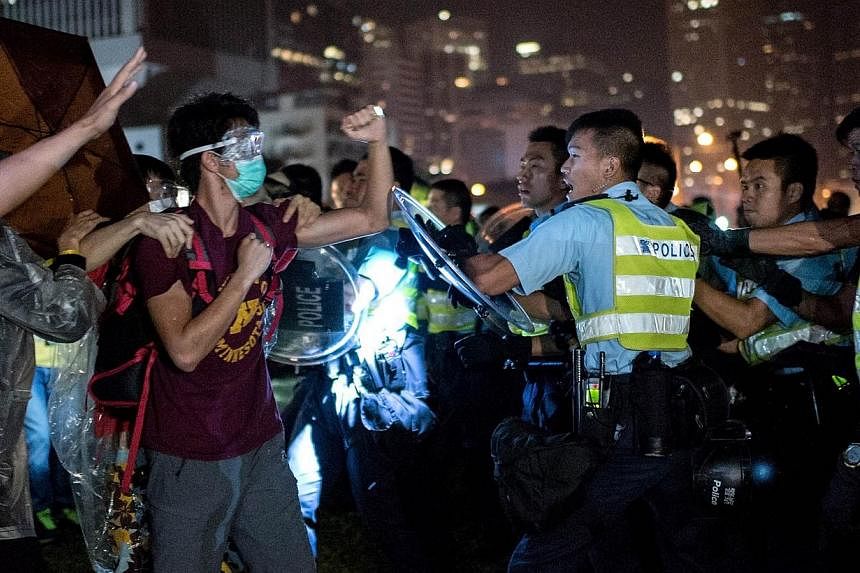 A pro-democracy protester (second, left) shakes his fist at police officers as they advance in Hong Kong on Oct 15, 2014.&nbsp;The BBC's website was blocked in China on Wednesday, one day after a video of Hong Kong police beating and kicking a pro-de