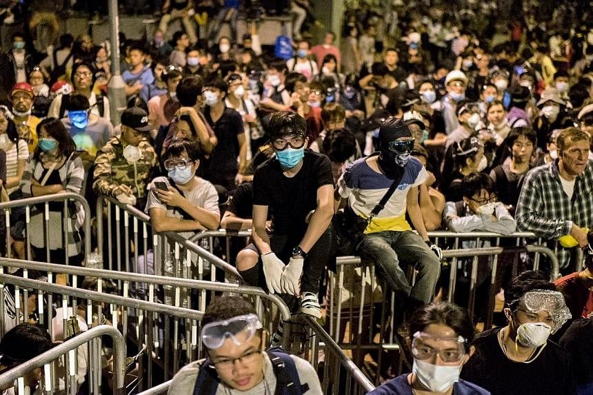Pro-democracy protesters gather near the central government offices in Hong Kong on Oct 15, 2014.&nbsp;IN AN indication that China expects the protest movement in Hong Kong to be fully over within the next three weeks, a Chinese government official h