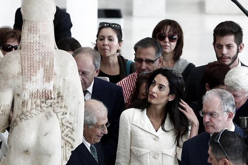 Human-rights lawyer Amal Alamuddin Clooney (centre) observes a Kore statue on Oct 15, 2014 during a visit at the Acropolis museum in Athens. A team of British lawyers is advising Greece on how to secure the return of the contested Parthenon marbles f