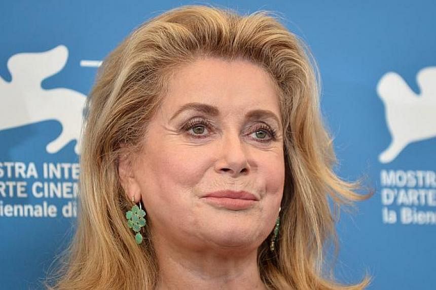 French actress Catherine Deneuve poses during the photocall of the movie 3 Coeurs presented in competition at the 71st Venice Film Festival on Aug 30, 2014 at Venice Lido. Deneuve said on Tuesday she was "pleased and touched" to accept a lifetime ach