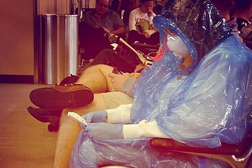 A female passenger dressed in a hazmat suit - complete with a full body gown, mask and gloves - was spotted on Oct 15 waiting for a flight at the Dulles International Airport outside Washington D.C. -- PHOTO: DAILYCALLER.COM