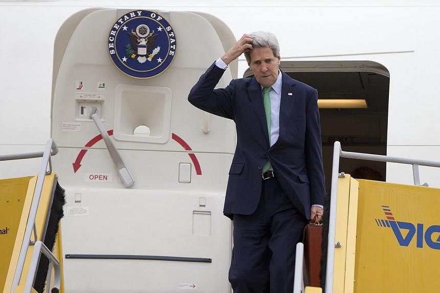 US Secretary of State John Kerry steps out from his plane as he arrives at Vienna International Airport in Vienna on Oct 15, 2014.&nbsp;Globe-trotting top US diplomat John Kerry was left hoofing it back on a commercial flight from Vienna Thursday, af