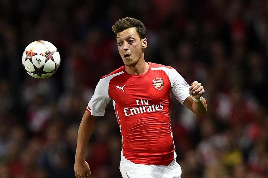 Arsenal's Mesut Oezil runs for the ball during their Champions League playoff soccer match against Besiktas at the Emirates stadium in London on Aug 27, 2014.&nbsp;Arsenal manager Arsene Wenger has confirmed that Oezil faces around six weeks out with
