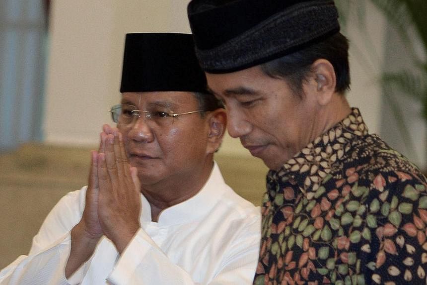 Indonesia's losing presidential candidate Prabowo Subianto (left) said on Friday his party would support President-elect Joko Widodo (right), but would not hesitate to criticise any of his policies that they opposed. -- PHOTO: AFP