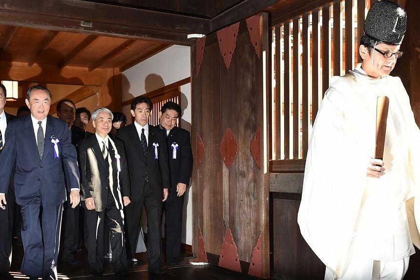 Japanese lawmakers follow a Shinto priest (right) during a visit to the controversial Yasukuni shrine on Oct 17, 2014. -- PHOTO: AFP