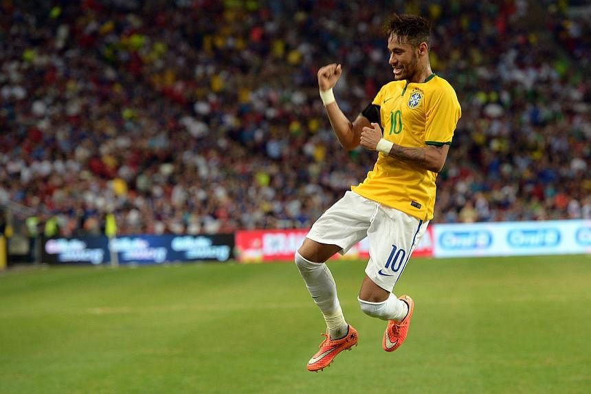 Brazil star Neymar celebrates a goal against Japan at the National Stadium. When he raced clear of Japan's backline to net his second of the night in Brazil's 4-0 win, assistant referee Lim Kok Heng was ready to flag offside for the goal. -- ST PHOTO