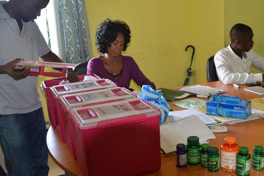 Members of the NGO U Fondation prepare medication on Oct 16, 2014 in Monrovia, before visiting quarantined people suffering from the Ebola virus. -- PHOTO: AFP