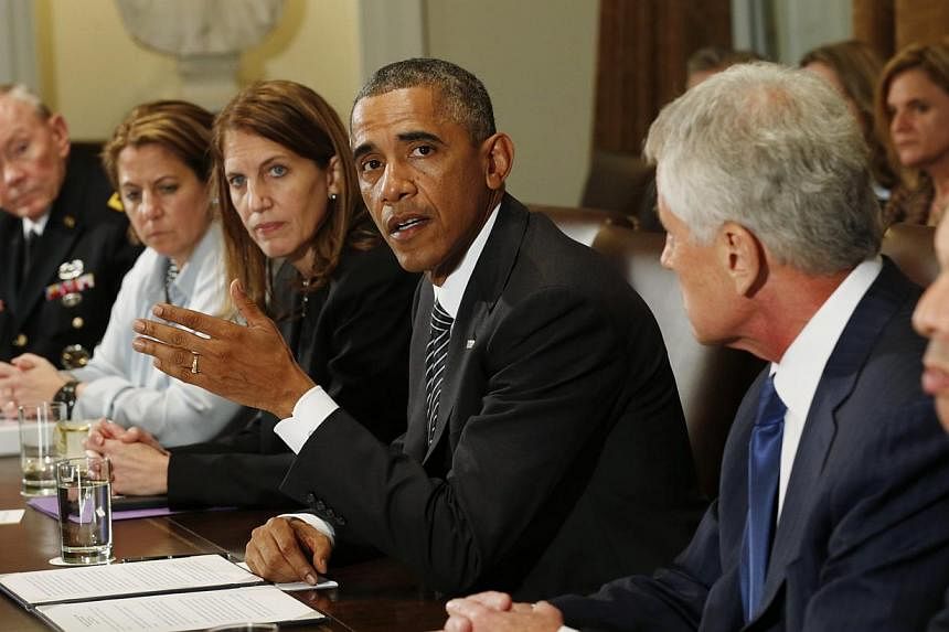 US President Barack Obama (middle) holds a meeting with cabinet agencies coordinating the government's Ebola response in the Cabinet Room of the White House in Washington on Oct 15, 2014. -- PHOTO: REUTERS