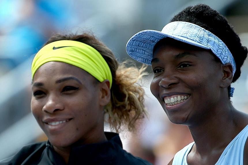 (From left) Serena Williams of the USA and Venus Williams of the USA pose before their women's semifinals match in the Rogers Cup at Uniprix Stadium on Aug 9, 2014 in Montreal, Canada. The president of the Russian Tennis Federation Shamil Tarpischev 