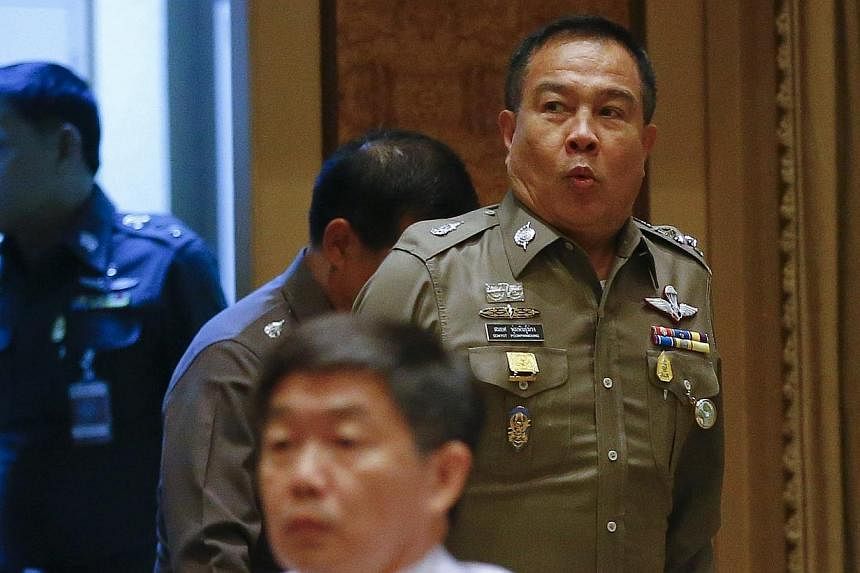 Chief of Royal Thai Police General Somyot Poompanmuang (right) reacts as he arrives to address reporters in Bangkok on Oct 7, 2014.&nbsp;Thailand has agreed to allow British police to join an investigation into the murder of two backpackers on a Thai