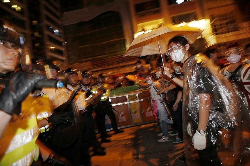 Policemen confront pro-democracy protesters during an attempt to remove them from a street in the Mong Kok shopping district of Hong Kong, on Oct 18, 2014. -- PHOTO: REUTERS