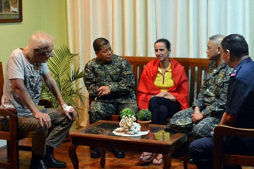 The two Germans kidnapped by Islamic militants, Stefan Okonek (left) and his partner Henrike Dielen (third from right) speaking to Philippine military and police officials in Zamboanga City, on Mindanao, after their release.