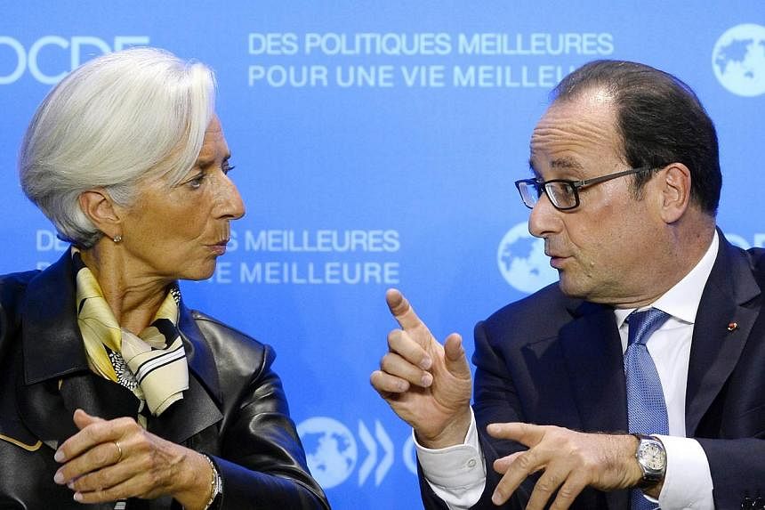 International Monetary Fund managing director Christine Lagarde (left) speaks with French President Francois Hollande during an OECD meeting in Paris, on Oct 17, 2014.&nbsp;Lagarde said Friday the plunge in global stock exchanges this week was due to