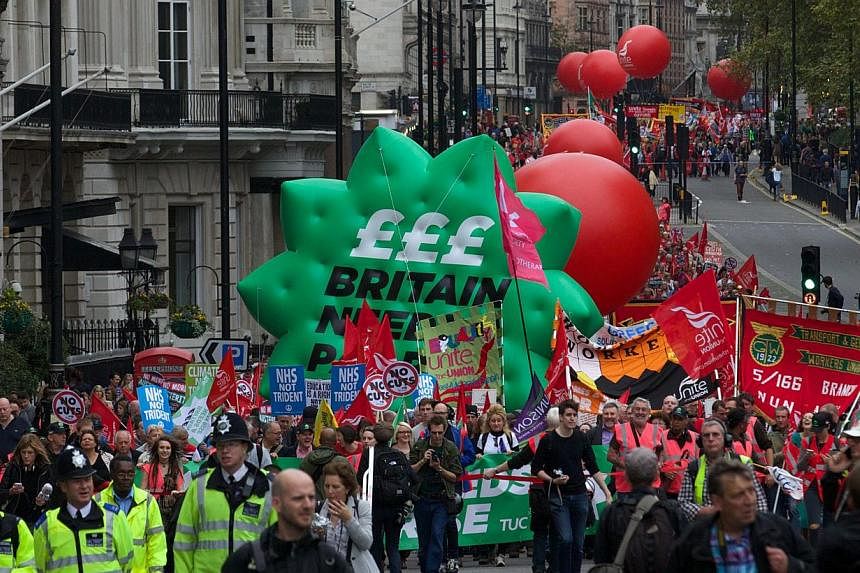 &nbsp;Thousands of people march in London on Oct 18, 2014, against falling real wages. -- PHOTO: AFP