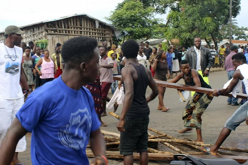 Residents place roadblocks on the street to demand faster removal of dead bodies infected with Ebola virus in the Aberdeen district of Freetown, Sierra Leone, Oct 14, 2014.&nbsp;Survivors of the deadly disease who met up in Sierra Leone on Thursday a