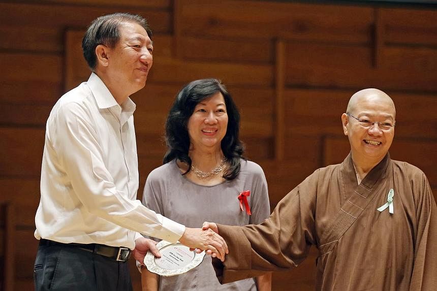 Deputy Prime Minister Teo Chee Hean&nbsp;is presented with a token of appreciation by HCA Hospice Care vice-president&nbsp;Mary Ong (centre) and Nectar Care Service president Venerable Seck Sian Siang.&nbsp;-- ST PHOTO: SEAH KWANG PENG