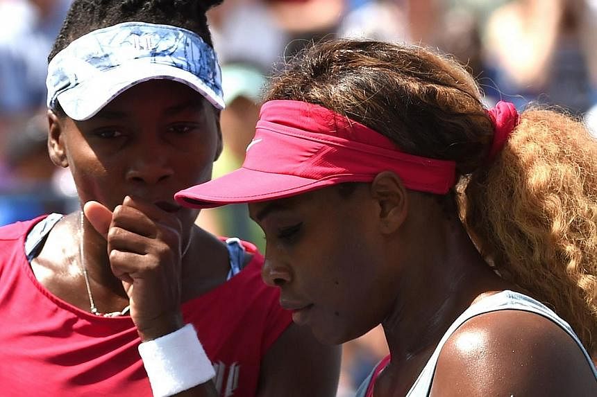 Venus and Serena (right) Williams of the US discuss strategy while playing Ekaterina Makarova and Elena Vesnina of Russia during their 2014 US Open Women's Doubles - Quarterfinals match at the USTA Billie Jean King National Tennis Center on Sept 2, 2