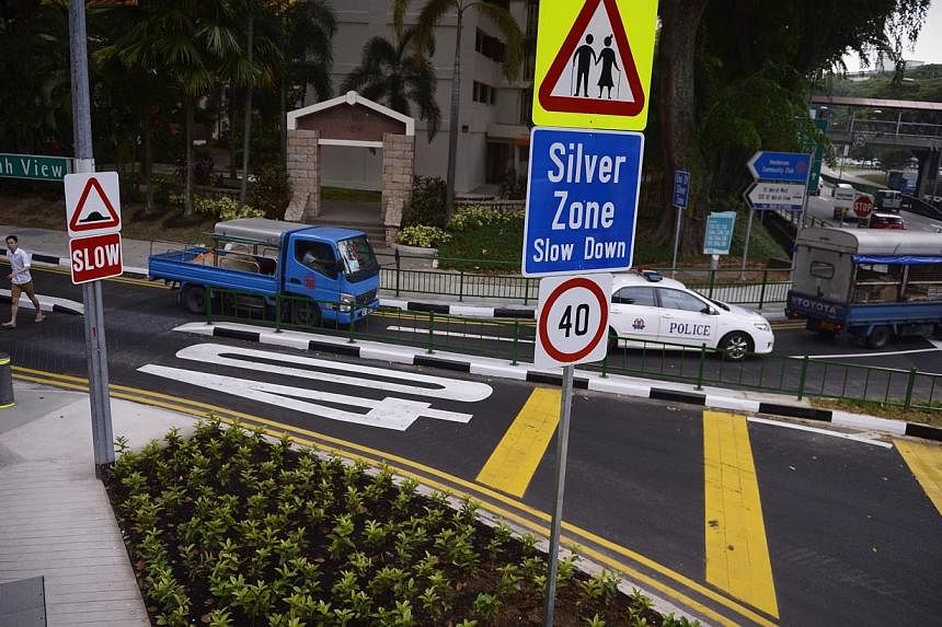 Ramps for wheelchairs and "look" ground markings (left) are some of the elder-friendly features at pedestrian crossings in Bukit Merah. Speed limit signs (right) and rumble stripes alert motorists that they are entering a Silver Zone.