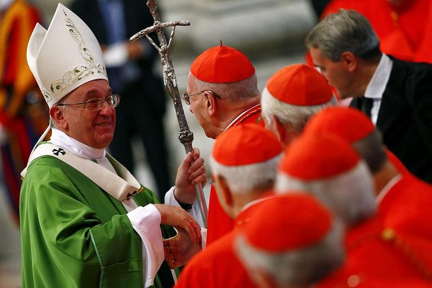 Pope Francis greets a cardinal as he leaves at the end of a mass to mark the opening of the synod on the family in Saint Peter's Square at the Vatican Oct 5, 2014. The final version of a controversial Vatican document issued on Saturday radically rev
