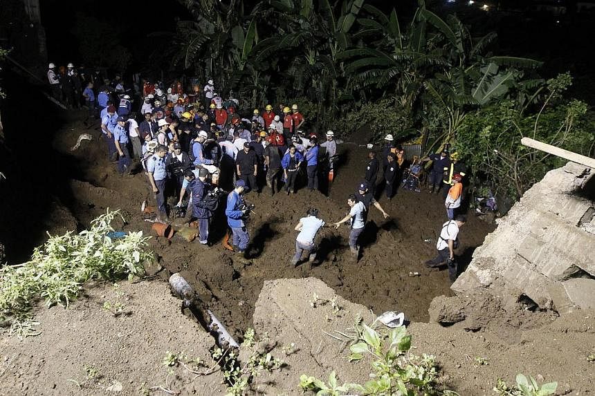 Rescue workers look for the bodies of eight people after the collapse of a perimeter wall at a residential area in Managua city on Oct 17, 2014. -- PHOTO: REUTERS