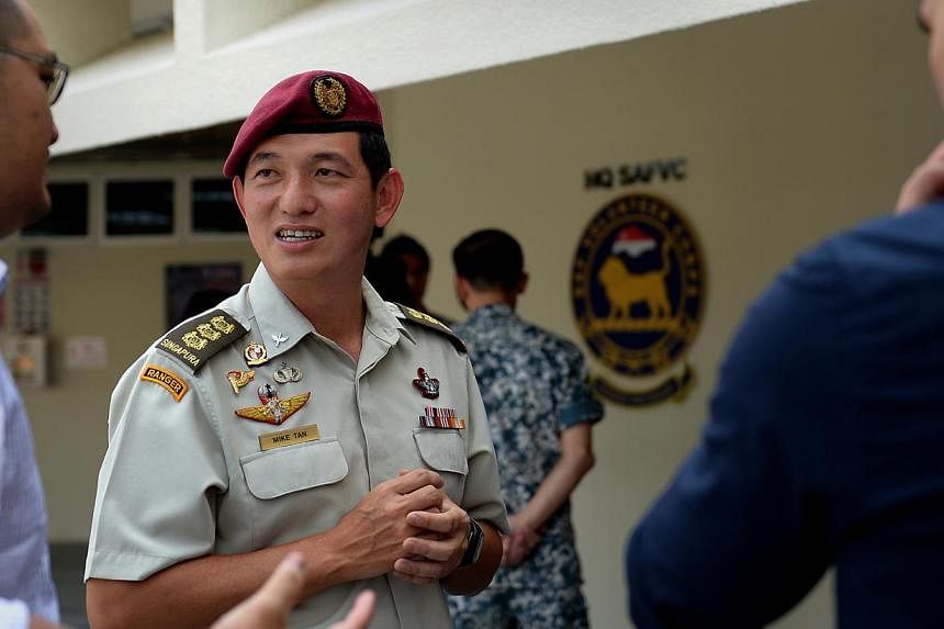 Colonel Mike Tan, who will head a newly formed Singapore Armed Forces (SAF) Volunteer Corps, having a brief chat with potential volunteers during a media briefing on Oct 10, 2014. -- ST PHOTO: JAMIE KOH