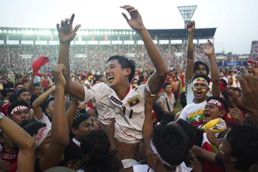 Than Paing of Myanmar (centre) is lifted up by fans as they celebrate after Myanmar won their AFC U-19 Championship quarter-final football match against the United Arab Emirates at Thuwanna stadium in Yangon on Oct 17, 2014.&nbsp;Asia's football gove