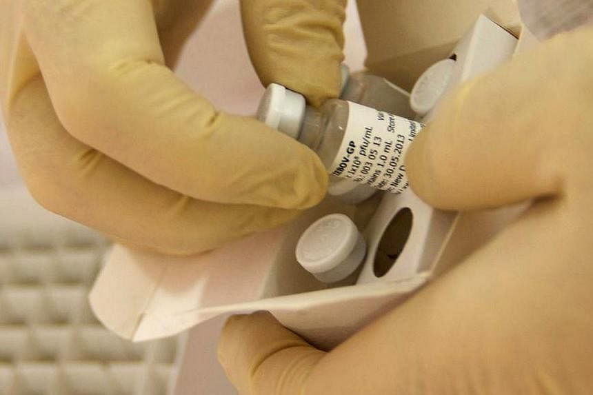 Scientists at the National Microbiology Lab in Winnipeg, Manitoba, prepare an experimental Ebola vaccine for shipment to the World Health Organization (WHO) in Geneva in this undated handout picture released on Oct 18, 2014. -- PHOTO: REUTERS