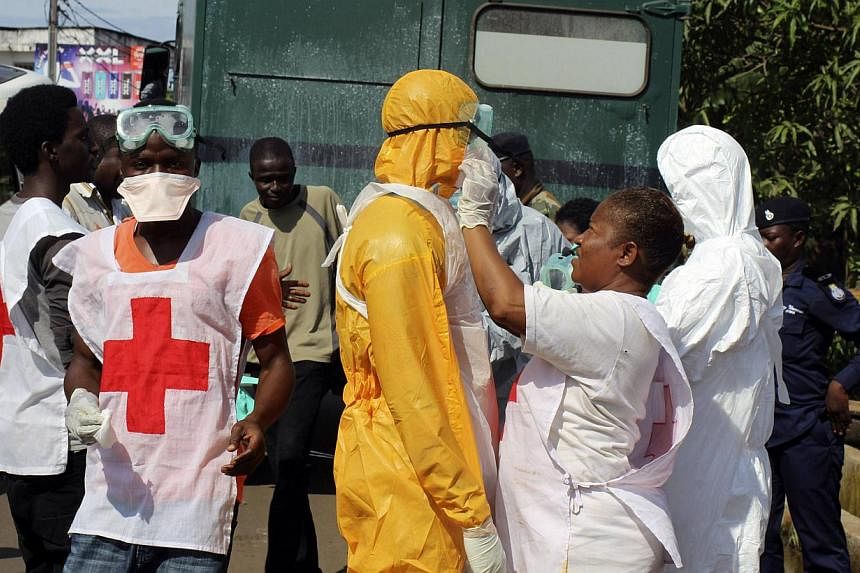 A health worker fixes another health worker's protective suit in the Aberdeen district of Freetown, Sierra Leone, Oct 14, 2014.&nbsp;A Norwegian woman who contracted the Ebola virus while working for Doctors Without Borders in Sierra Leone has been c