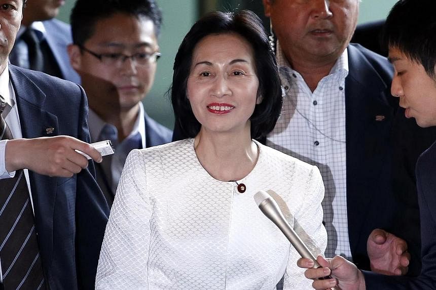 Japan's Justice Minister Midori Matsushima (centre) reacts as she is surrounded by reporters upon her arrival at Prime Minister Shinzo Abe's official residence for a meeting with Mr Abe in Tokyo on Oct 20, 2014. -- PHOTO: REUTERS