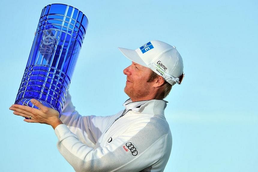 Finnish golfer Mikko Ilonen celebrates with the trophy after beating Swedish golfer Henrik Stenson in the final of the Volvo World Match Play Championship at The London Golf Club in Kent, south-east England, on Oct 19, 2014. -- PHOTO: AFP