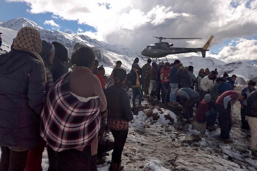 Nepalese Army helicopter rescues survivors of a snow storm in Manang District, along the Annapurna Circuit Trek. -- PHOTO: AFP