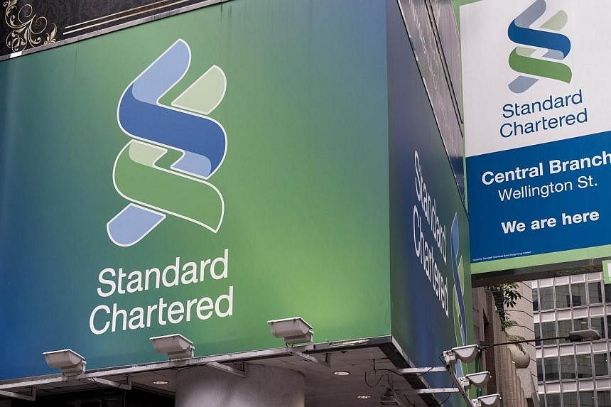 This Aug 6, 2014 file photo shows Standard Chartered billboards as they hang above a bank branch in Hong Kong. -- PHOTO: AFP