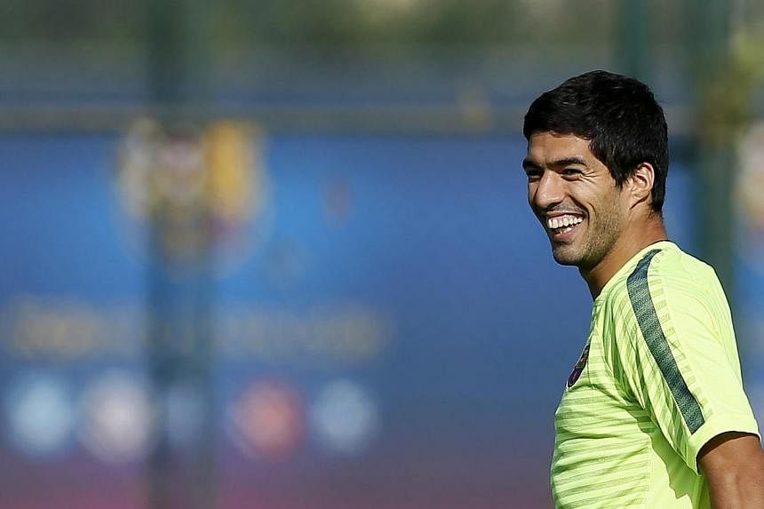 Barcelona's players Luis Suarez smiles during a training session at Joan Gamper training camp, near Barcelona. -- PHOTO: REUTERS