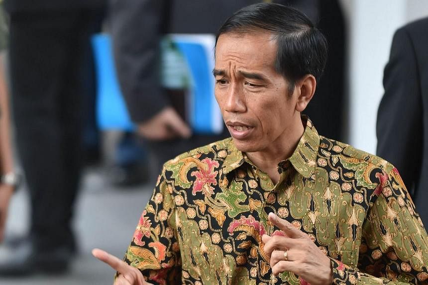 Indonesian President Joko Widodo answers journalists' questions outside the Palace in Jakarta on Oct 21, 2014 during his first day as President after his inauguration on Oct 20, 2014. -- PHOTO: AFP &nbsp;