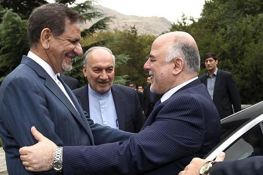 Iran's First Vice President Eshaq Jahangiri (left) welcoming Iraqi Prime Minister Haidar al-Abadi (right) at Saadabad Palace in Tehran on Oct 21, 2014.&nbsp;Iraqi Prime Minister Haidar al-Abadi said Tuesday his country was at war with "terrorists" th