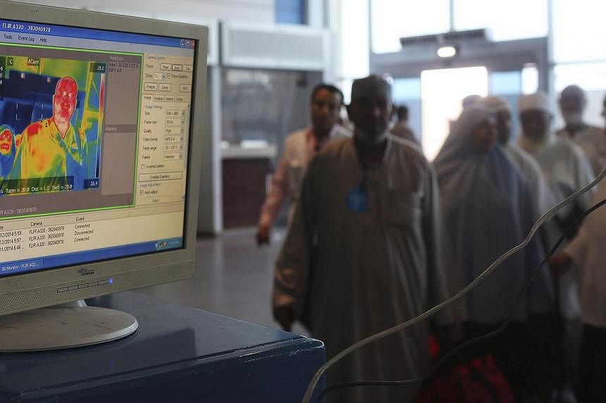 Health workers use an infrared scanner to scan the temperatures of passengers returning from haj pilgrimage in Saudi Arabia, at Cairo Airport on Oct 13, 2014.&nbsp;A new device similar to a simple pregnancy home-test could allow doctors to diagnose a
