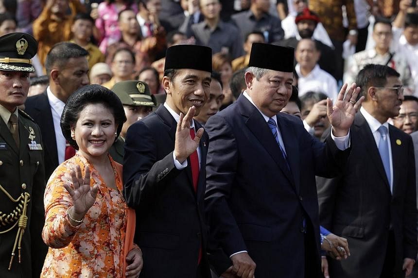 Indonesian President Joko Widodo (third left), with First Lady Iriana Widodo (second left), is accompanied by outgoing president Susilo Bambang Yudhoyono (fouth left) at the Presidential Palace in Jakarta during the official welcome ceremony on Oct 2
