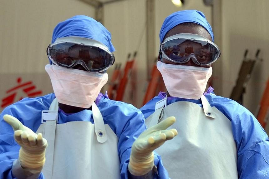 Liberian health workers are seen at the NGO Medecins Sans Frontieres (Doctors Without Borders) Ebola treatment center in Monrovia on Oct 18, 2014. The medical charity said on Tuesday it had saved a 1000th patient from the deadly epidemic. -- PHOTO: A