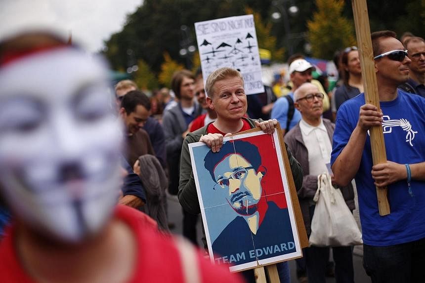 A man holds a placard with a portrait of former US National Security Agency contractor Edward Snowden during a "Freiheit Statt Angst" (Freedom instead of Fear) protest calling for the protection of digital data privacy and the reigning in of digital 