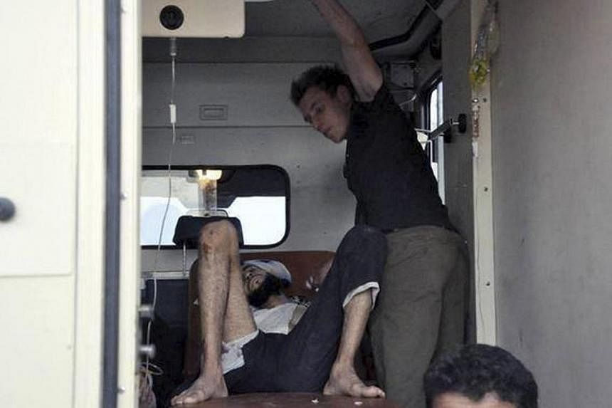 Abdul-Rahman Kassig works as a medic to help a wounded man as he provided medical aid and first-aid training to those involved in the Syrian conflict in his work with Special Emergency Response and Assistance (SERA) in this handout photo courtesy of 