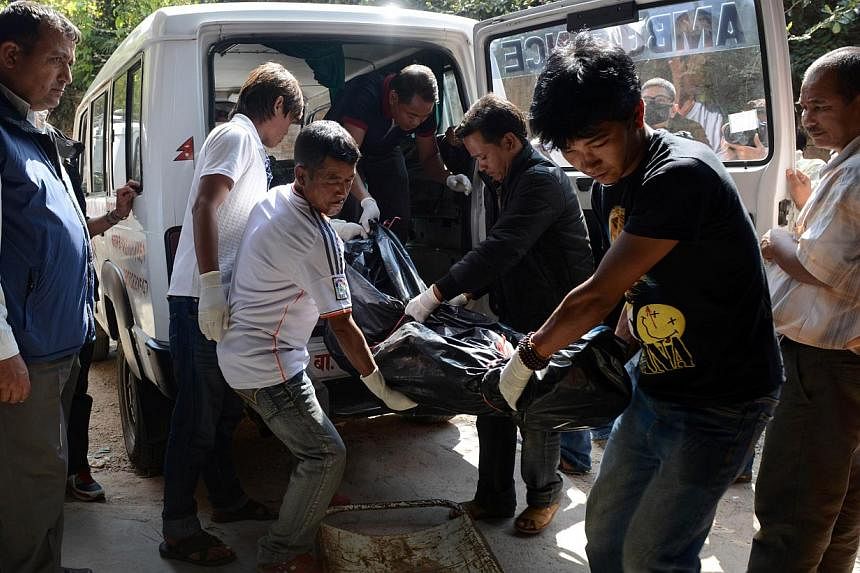 Volunteers shift the recovered body of a trekker killed in a snowstorm and an avalanche on Nepal's Annapurna Circuit, at the Teaching Hospital morgue in Kathmandu on Oct 20, 2014.&nbsp;-- PHOTO: AFP