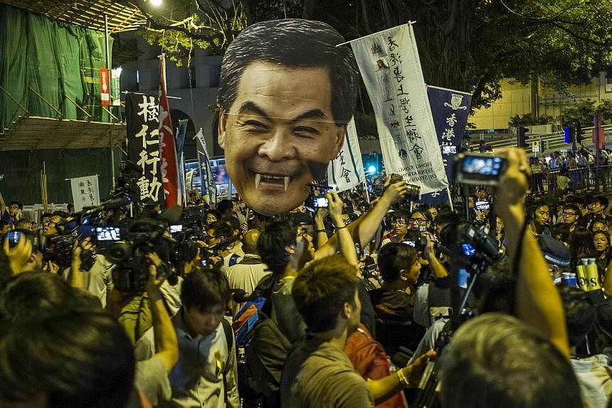 Students march to the Government House in Hong Kong holding a portrait of Chief Executive Leung Chun Ying, on Sept 25, 2014. -- PHOTO: AFP&nbsp;