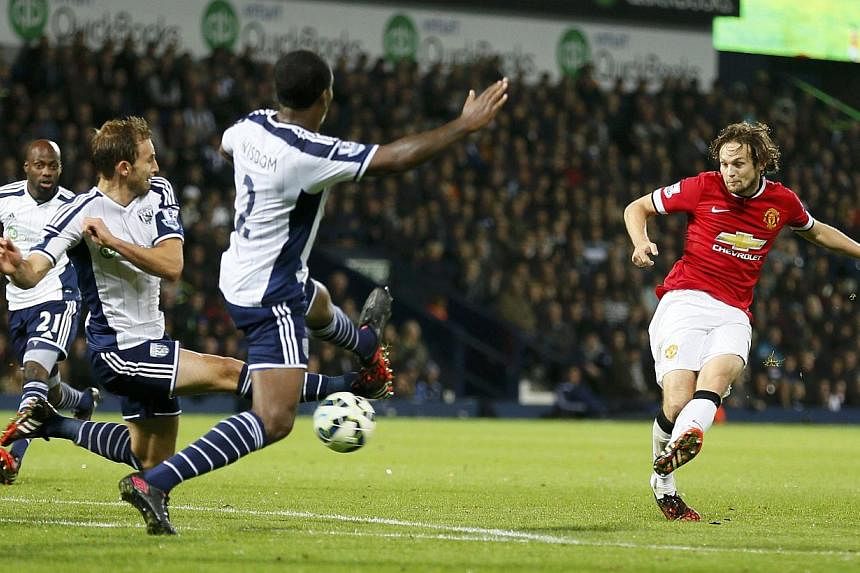 Daley Blind of Manchester United (right) shoots to score against West Bromwich Albion during their English Premier League match at The Hawthorns in West Bromwich on Oct 20, 2014. -- PHOTO: REUTERS