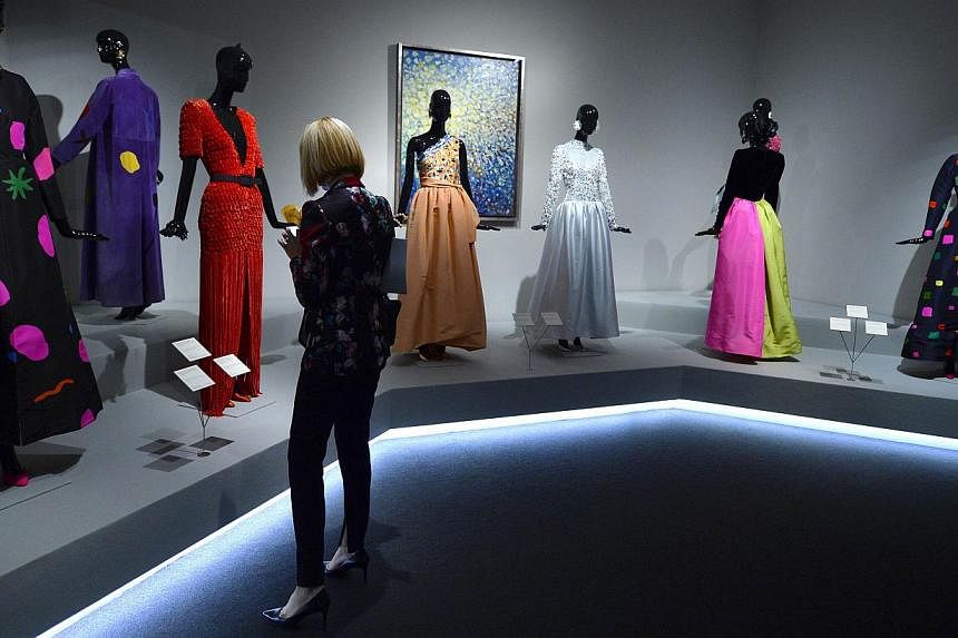 A woman looks at creations displayed at the exhibition titled "Hubert de Givenchy" at the Thyssen-Bornemisza museum in Madrid on Oct 20, 2014. -- PHOTO: AFP