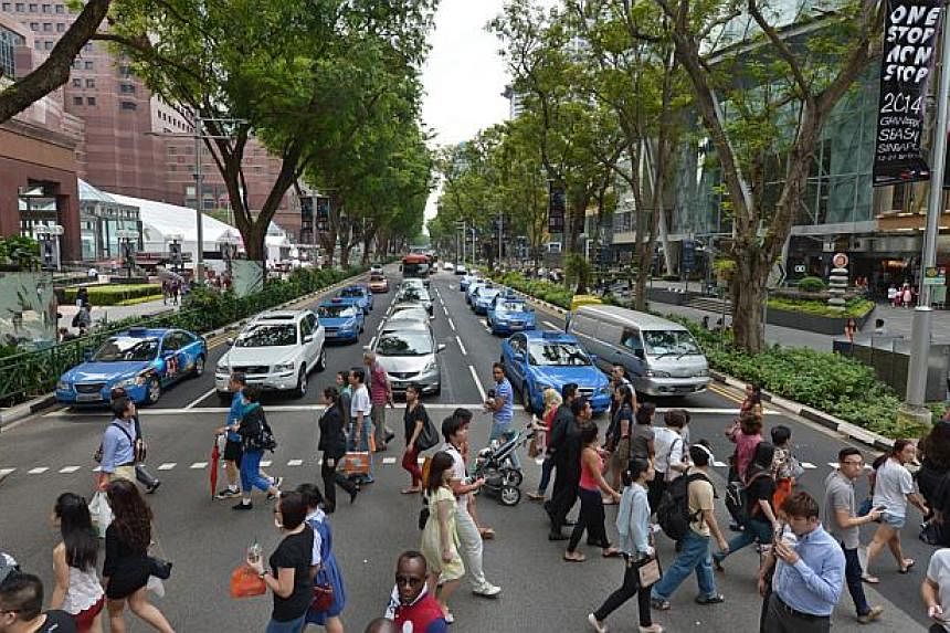 Shoppers crossing at the traffic crossing between Ngee Ann City and Paragon at Orchard Road on Sept 25, 2014. -- PHOTO: ST FILE